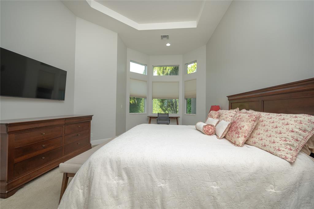 6359 Bellamalfi Street Boca Raton, FL 33496 - Photo 29 of 86 a bedroom with a bed and a flat tv screen on dresser