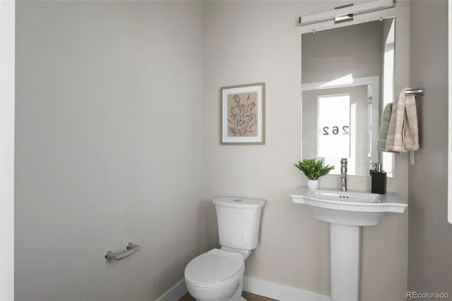 a bathroom with a sink mirror and toilet