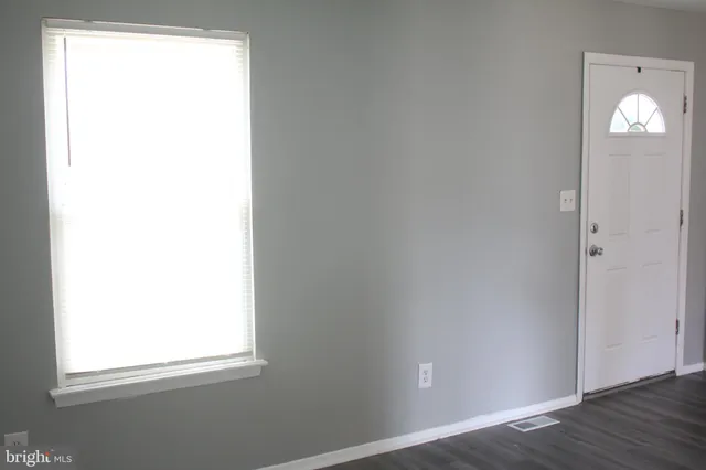 a view of a small space with wooden floor and a window