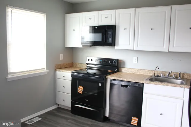 a kitchen with stainless steel appliances granite countertop a sink and a microwave