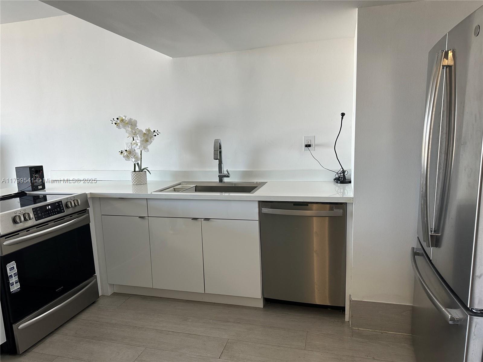 555 Northeast 15th Street, Unit 508 Miami, FL 33132 - Photo 3 of 25 a kitchen with a stove sink and refrigerator