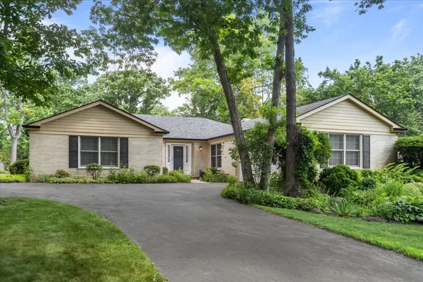 a front view of a house with a yard and potted plants