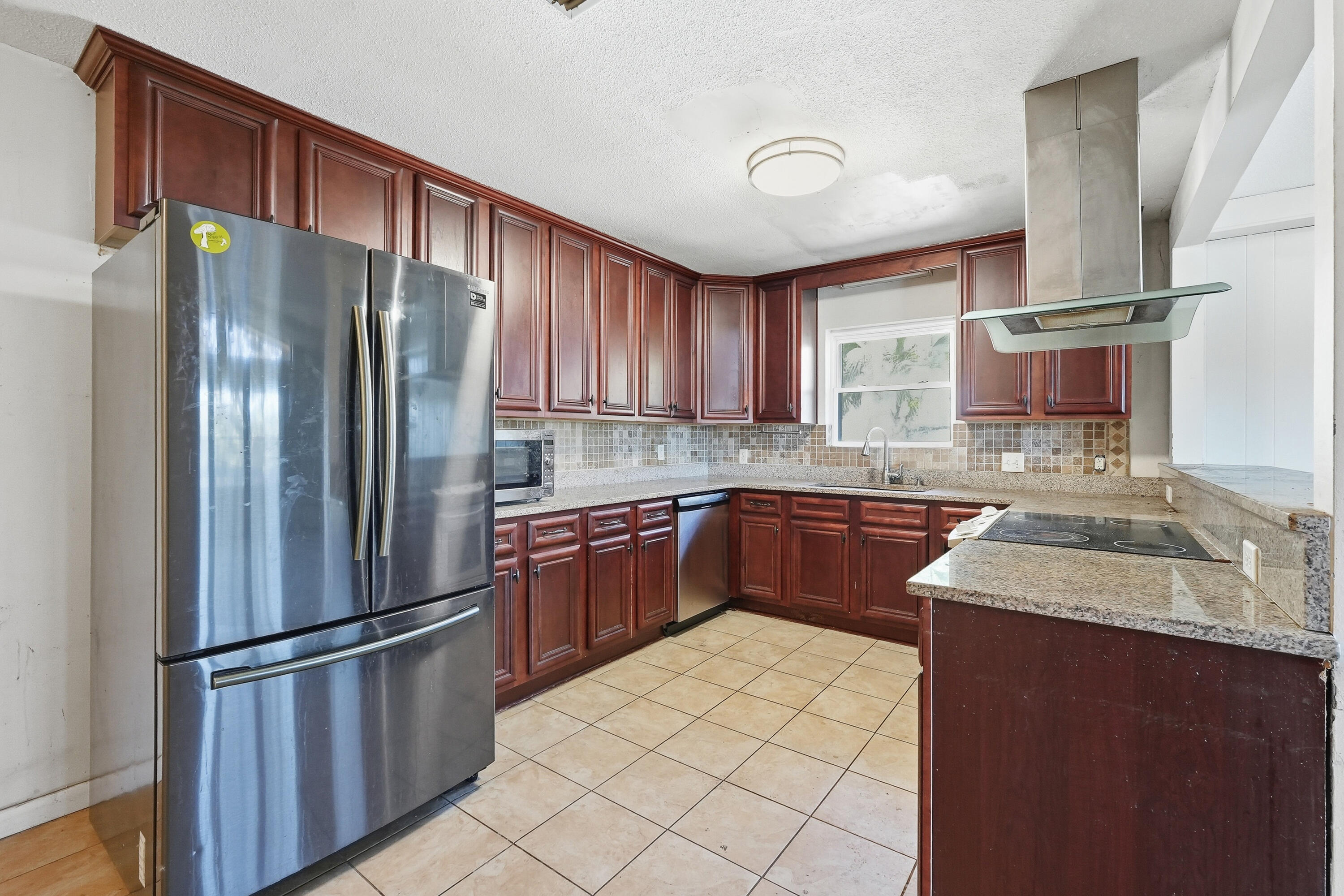 a kitchen with stainless steel appliances granite countertop a refrigerator stove and sink