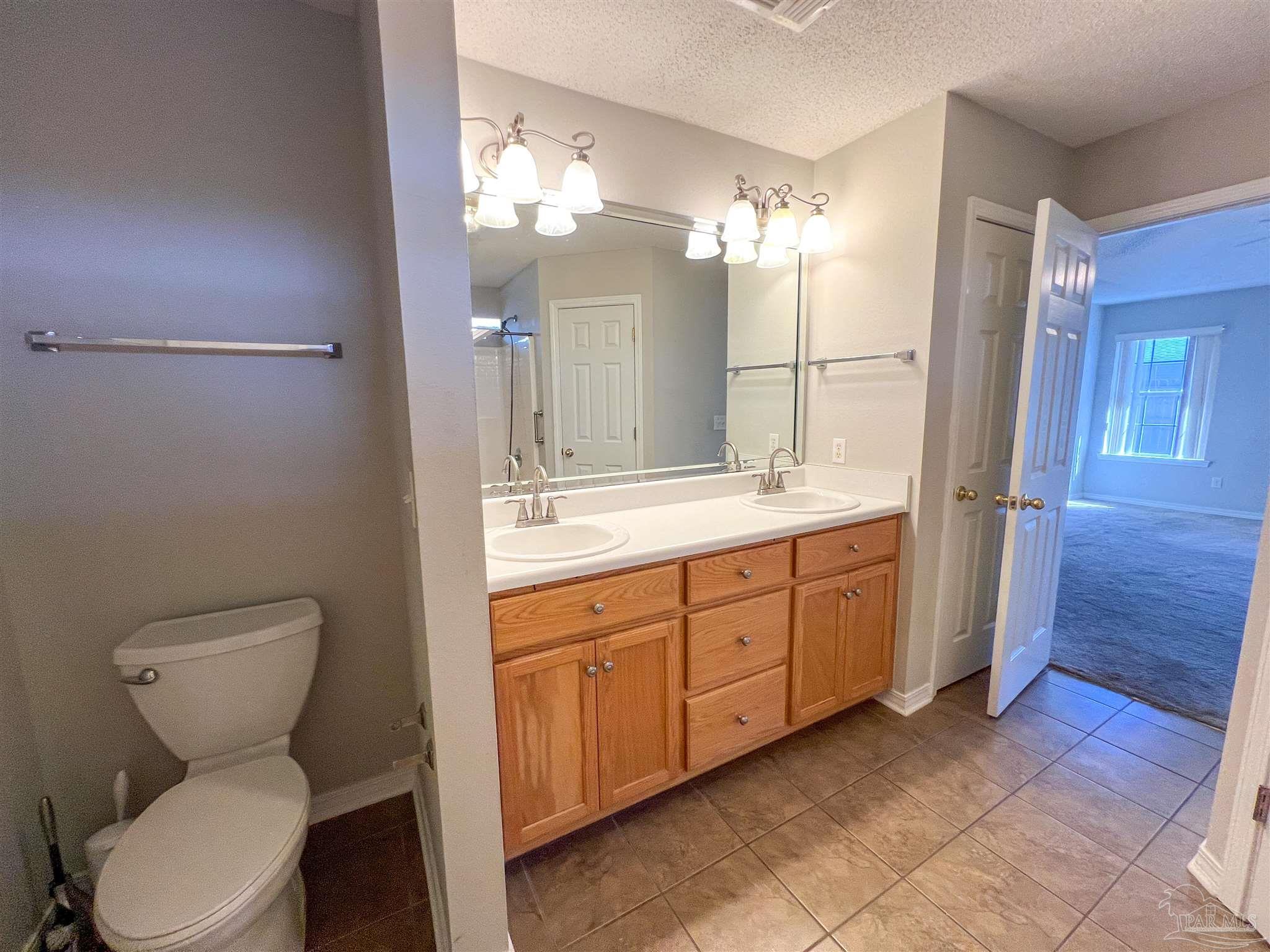 2967 Creole Way Pensacola, FL 32526 - Photo 18 of 30 a bathroom with a toilet sink and mirror