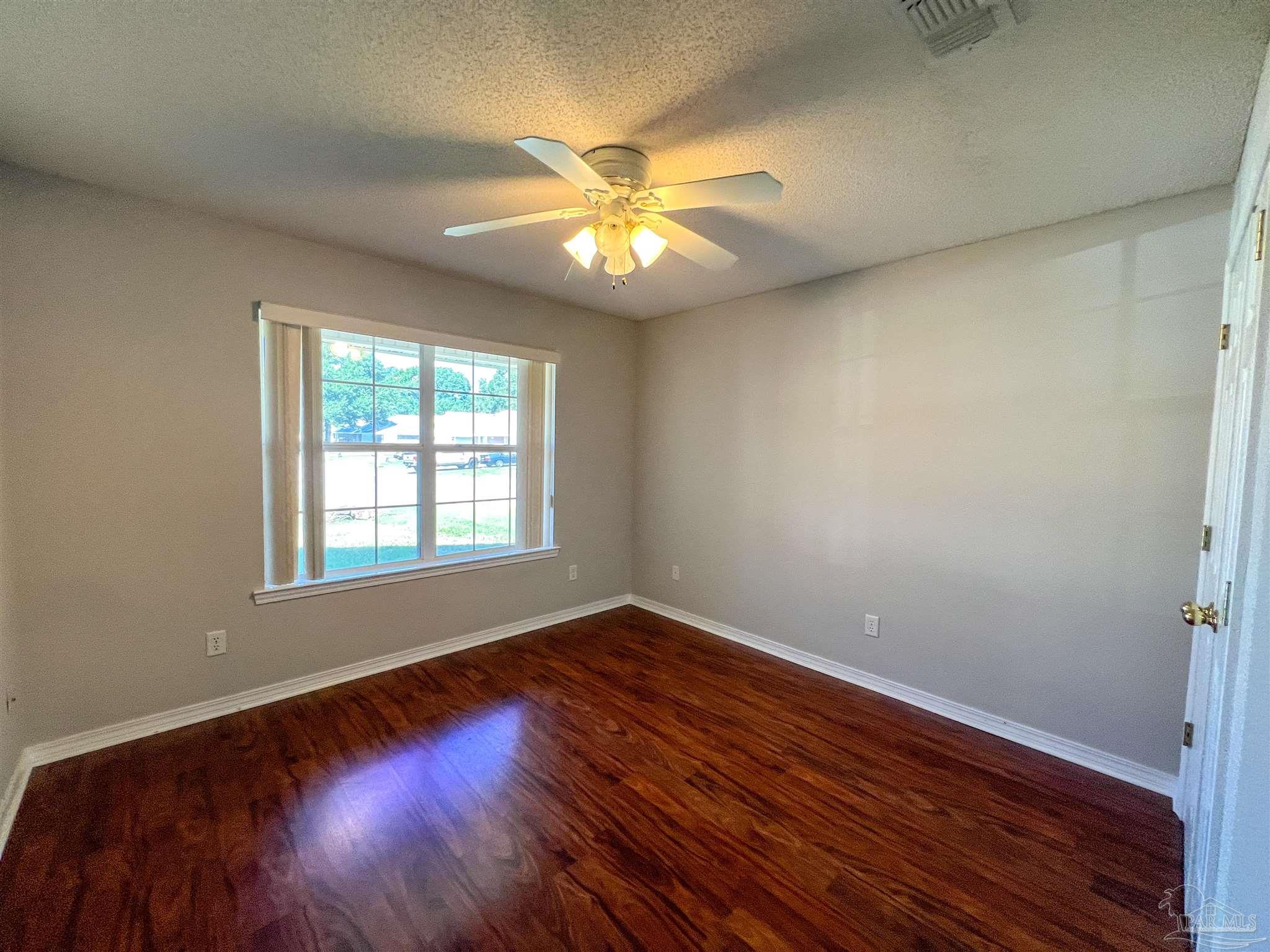 2967 Creole Way Pensacola, FL 32526 - Photo 21 of 30 wooden floor in an empty room with a window