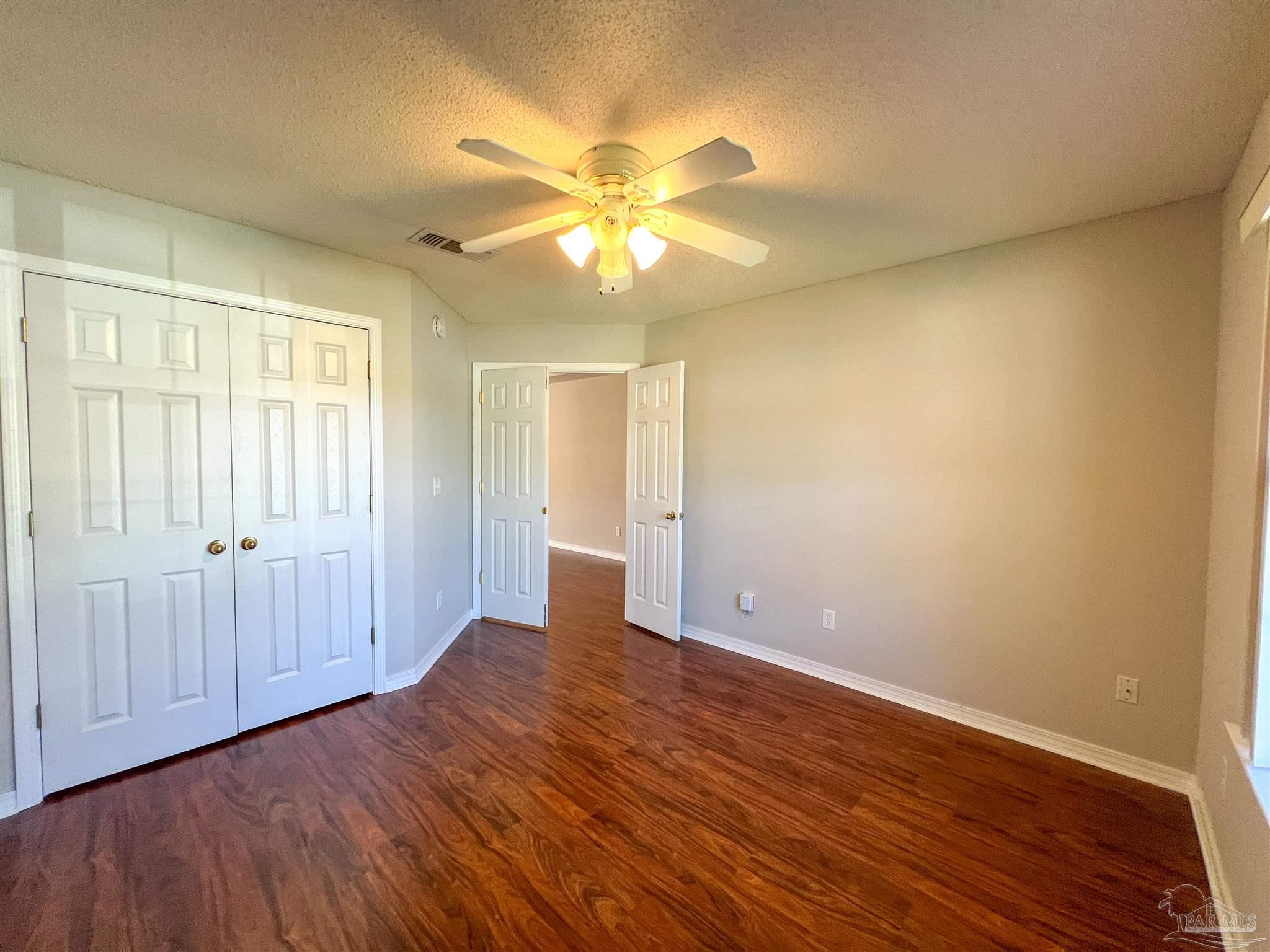 2967 Creole Way Pensacola, FL 32526 - Photo 22 of 30 a view of an empty room with wooden floor and a window