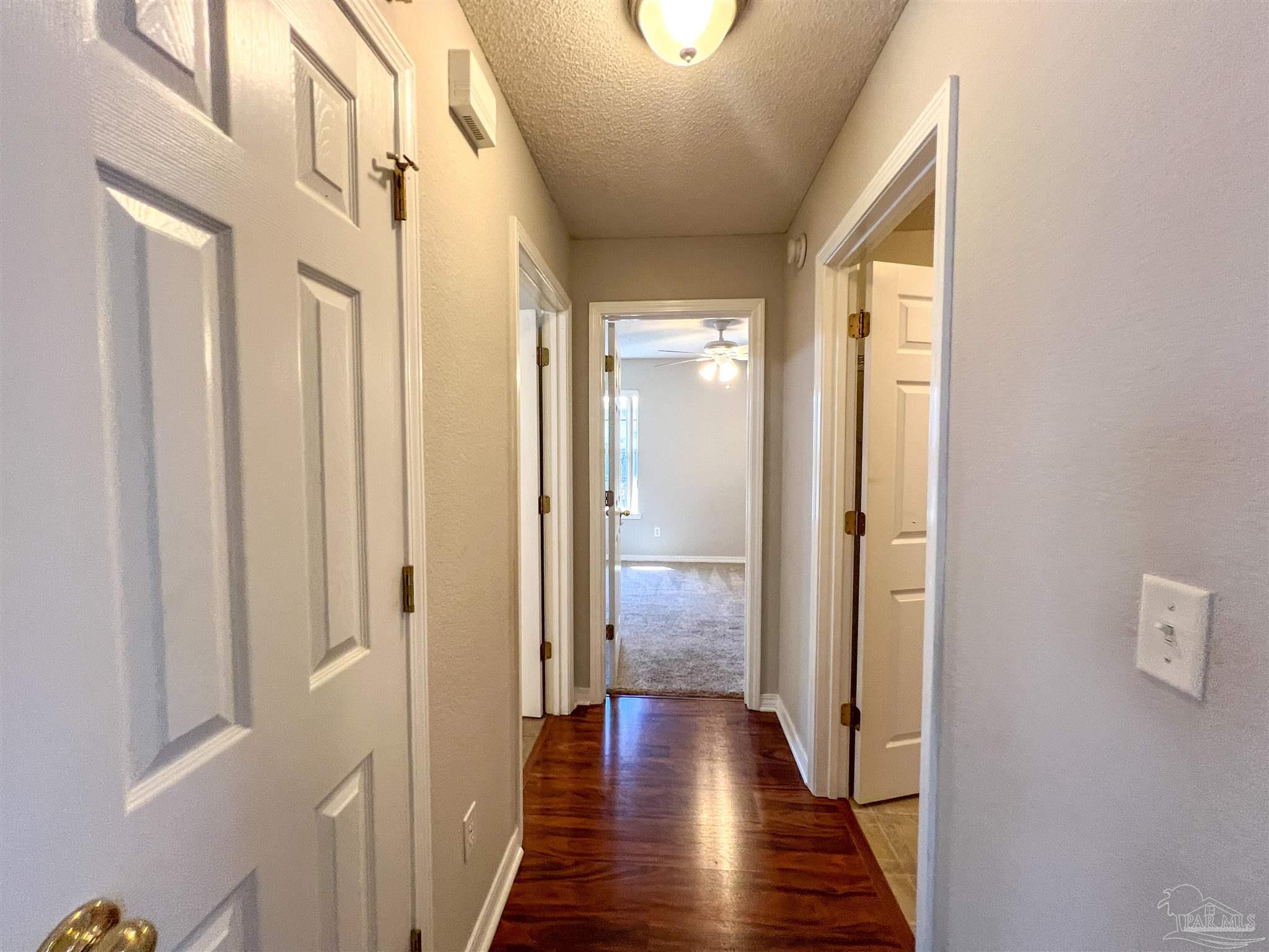 2967 Creole Way Pensacola, FL 32526 - Photo 23 of 30 a view of a hallway with wooden floor and staircase
