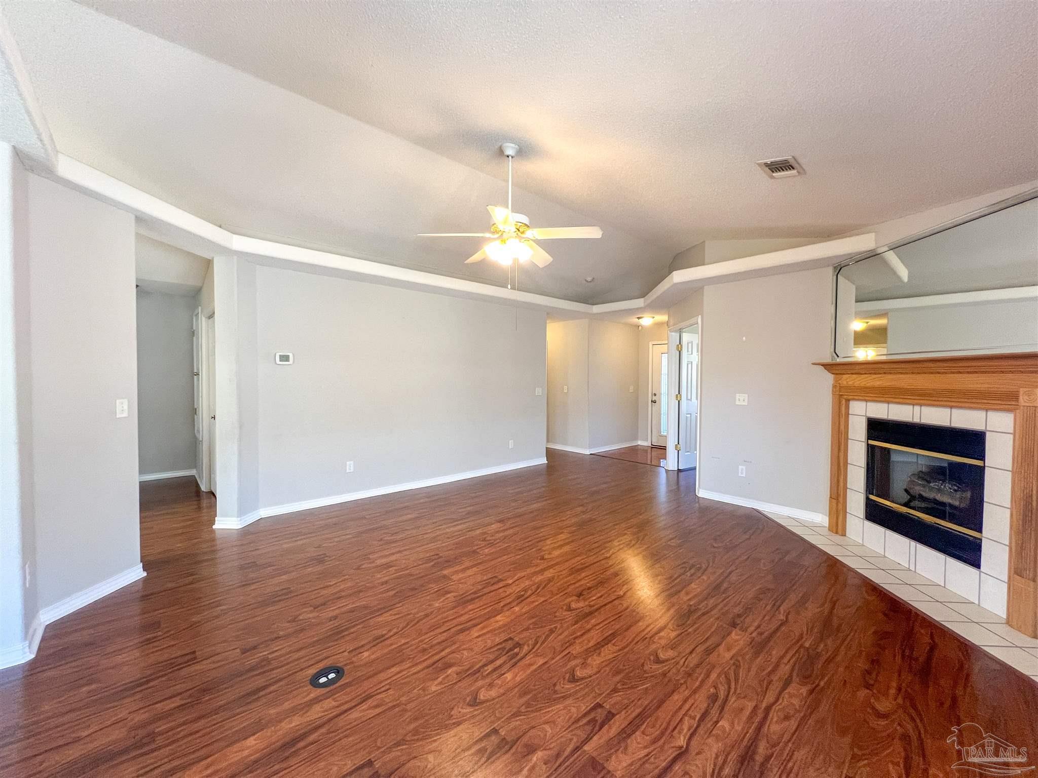 2967 Creole Way Pensacola, FL 32526 - Photo 5 of 30 a view of an empty room with wooden floor fireplace and a window