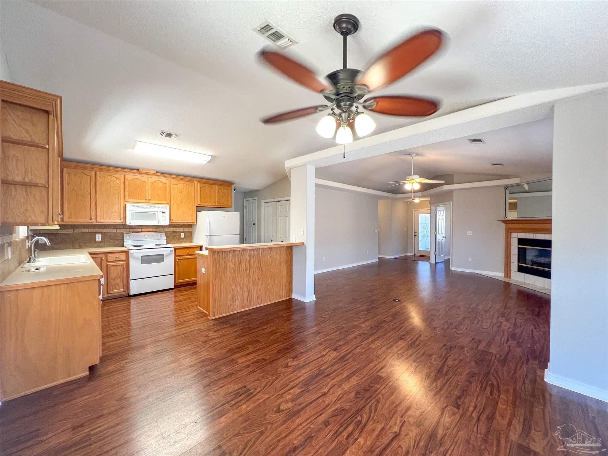 2967 Creole Way Pensacola, FL 32526 - Photo 8 of 30 a view of a kitchen center island wooden floor and a ceiling fan