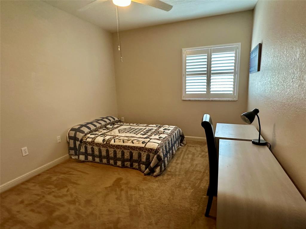 7727 Southampton Terrace, Unit 303 Tamarac, FL 33321 - Photo 11 of 23 a bedroom with a bed and a chair in it