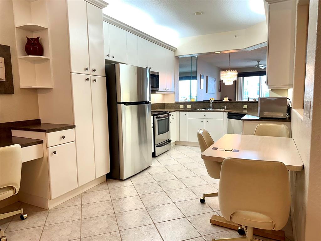 7727 Southampton Terrace, Unit 303 Tamarac, FL 33321 - Photo 13 of 23 a kitchen with stainless steel appliances kitchen island granite countertop a sink a stove a refrigerator and cabinets