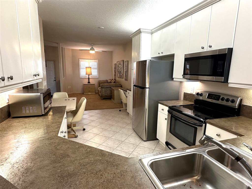 7727 Southampton Terrace, Unit 303 Tamarac, FL 33321 - Photo 16 of 23 a kitchen with a refrigerator a stove top oven a sink and dishwasher