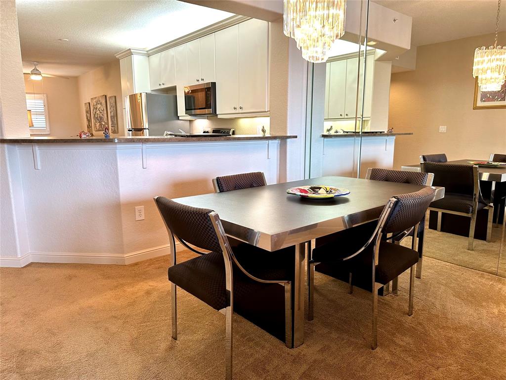 7727 Southampton Terrace, Unit 303 Tamarac, FL 33321 - Photo 18 of 23 a dining room with stainless steel appliances a table and chairs