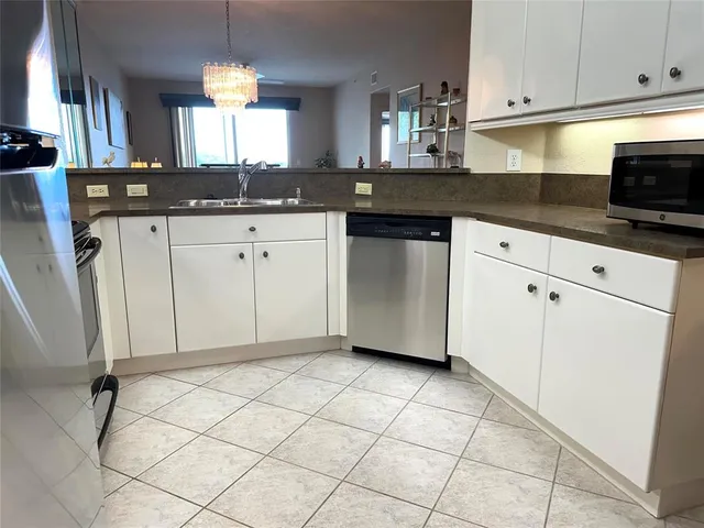 a kitchen with granite countertop white cabinets and white appliances