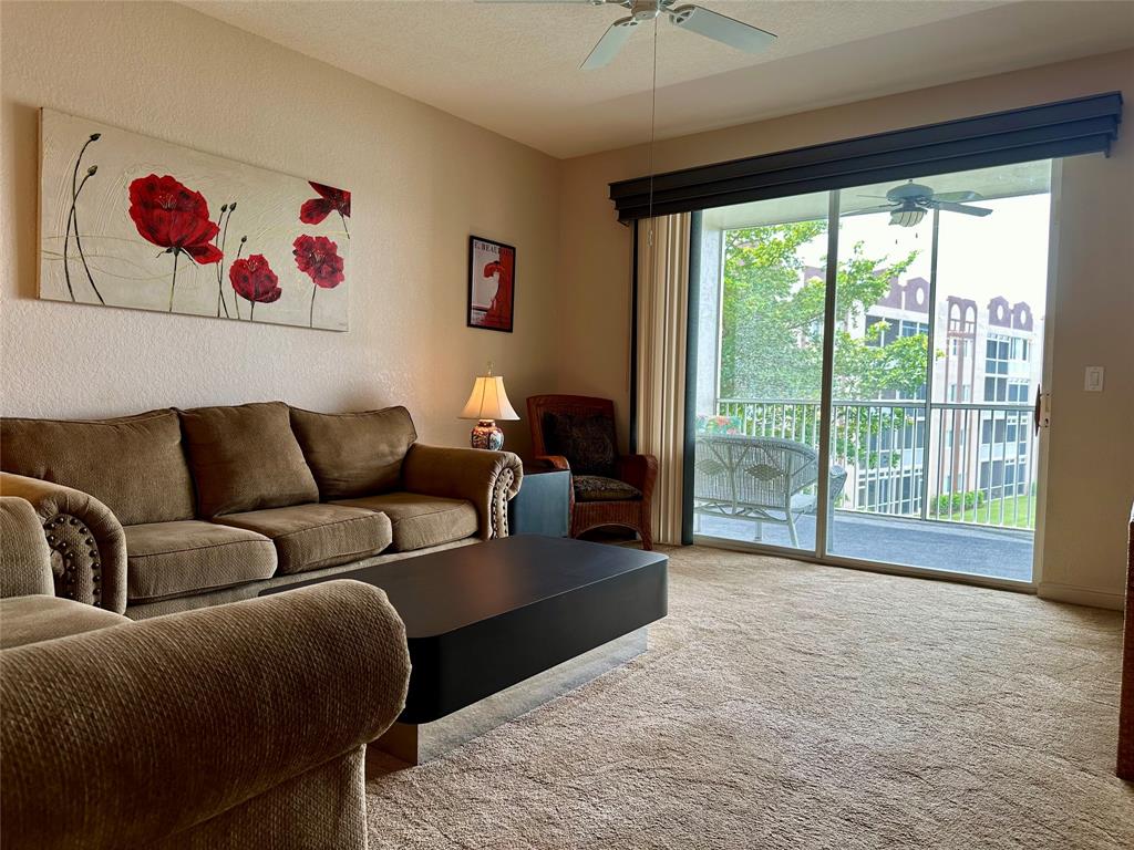 7727 Southampton Terrace, Unit 303 Tamarac, FL 33321 - Photo 7 of 23 a living room with furniture cabinets and a large window