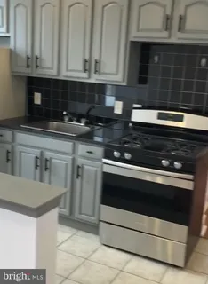 a kitchen with granite countertop white cabinets and stainless steel appliances