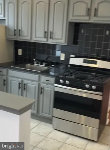 a kitchen with granite countertop white cabinets and stainless steel appliances