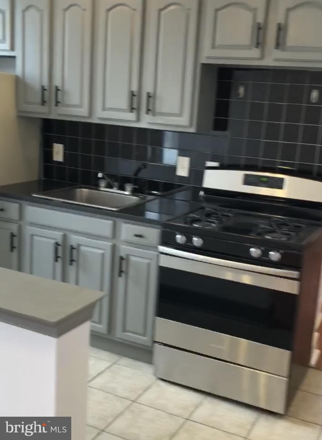 1523 Christian Street, Unit 2R Philadelphia, PA 19146 - Photo 2 of 18 a kitchen with granite countertop white cabinets and stainless steel appliances