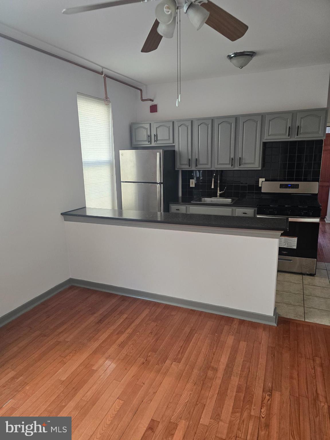 1523 Christian Street, Unit 2R Philadelphia, PA 19146 - Photo 4 of 18 a kitchen with stainless steel appliances wooden floor and a refrigerator