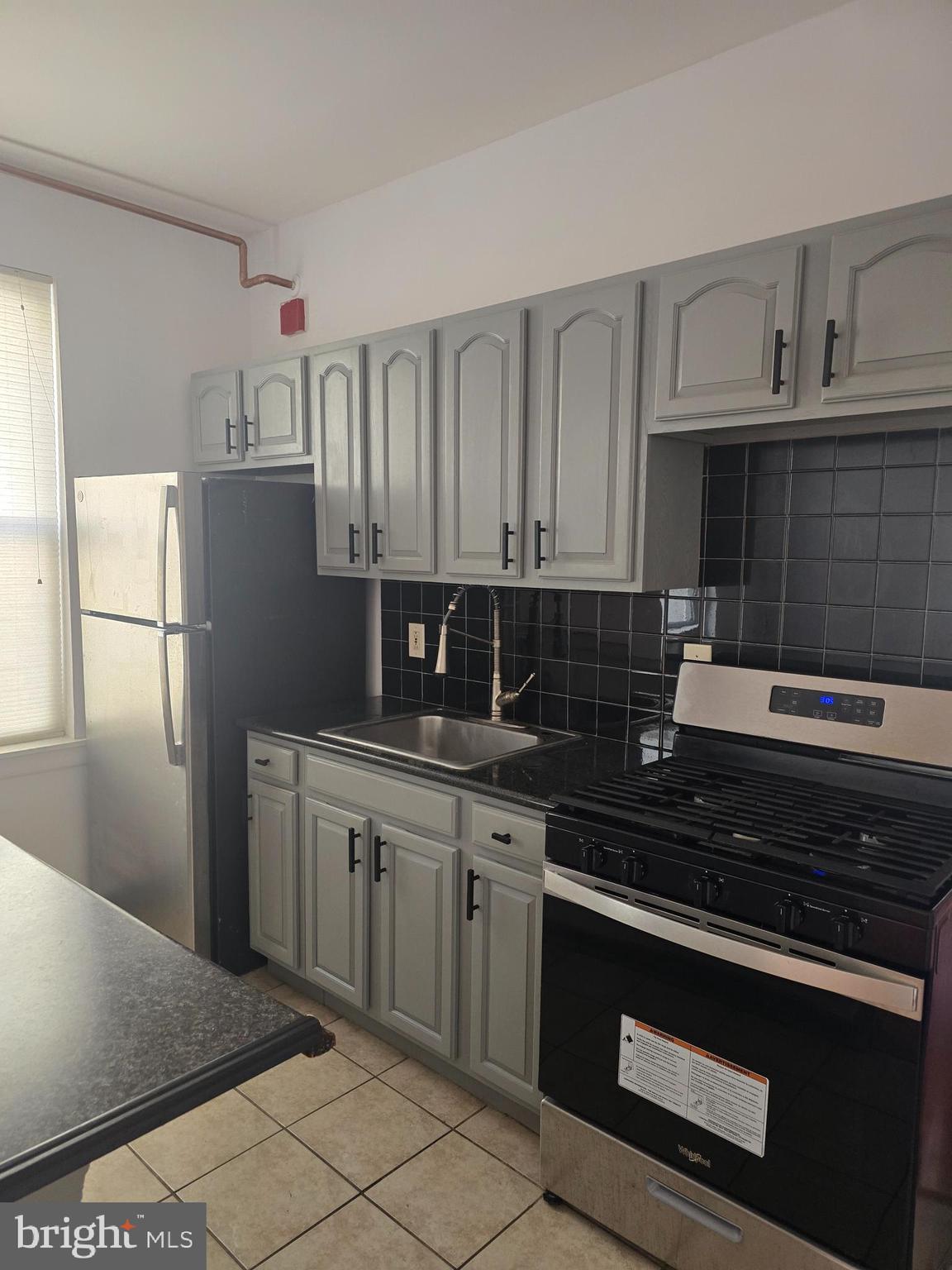 1523 Christian Street, Unit 2R Philadelphia, PA 19146 - Photo 8 of 18 a kitchen with granite countertop a refrigerator stove and sink