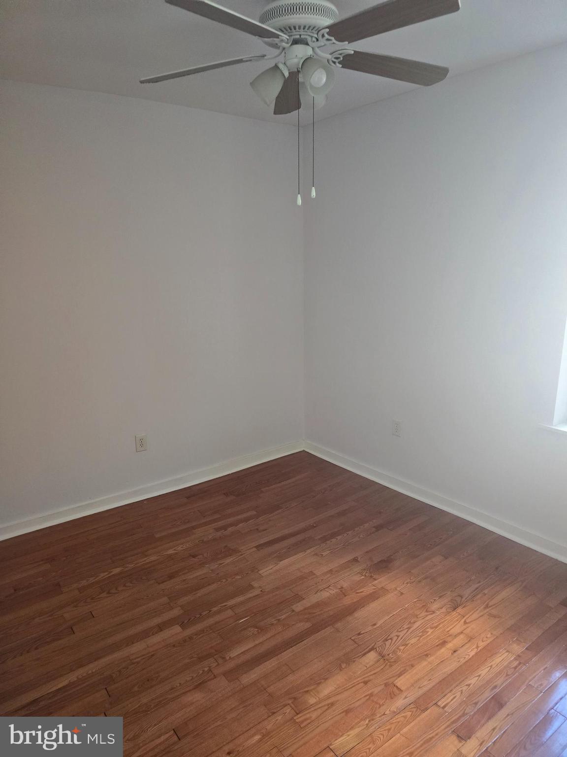 1523 Christian Street, Unit 2R Philadelphia, PA 19146 - Photo 10 of 18 a view of an empty room with wooden floor and a ceiling fan