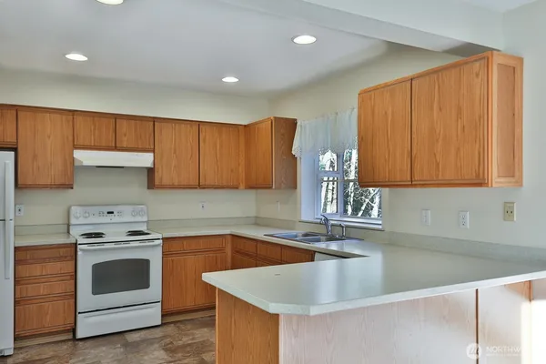 a kitchen with granite countertop a sink stainless steel appliances and cabinets