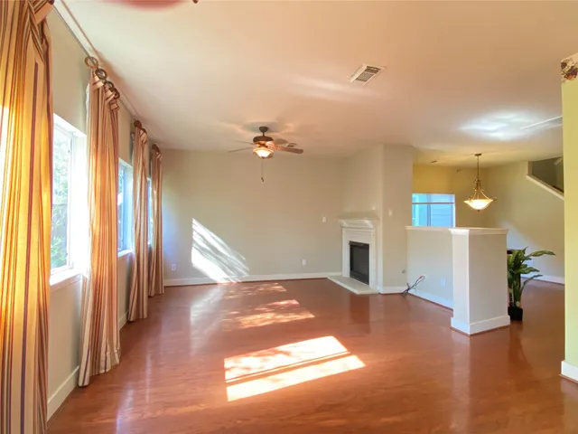 a view of a livingroom with wooden floor and a kitchen