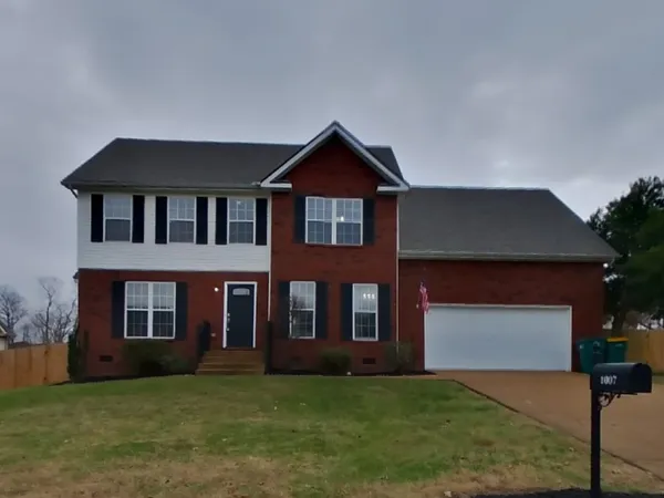 a front view of a house with a yard and garage