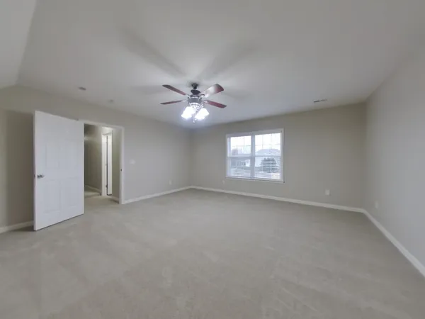 an empty room with windows and chandelier fan