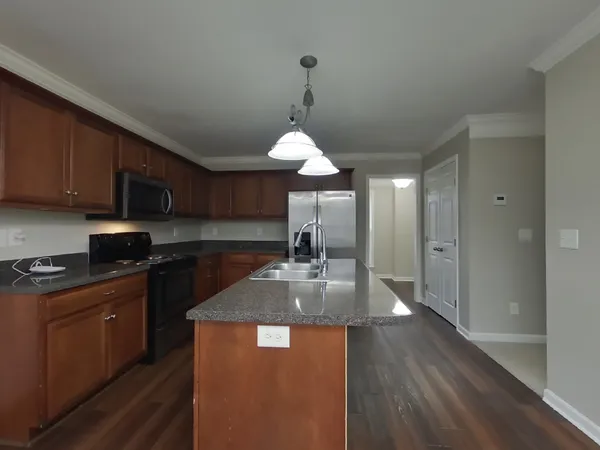 a kitchen with granite countertop a sink stainless steel appliances and cabinets