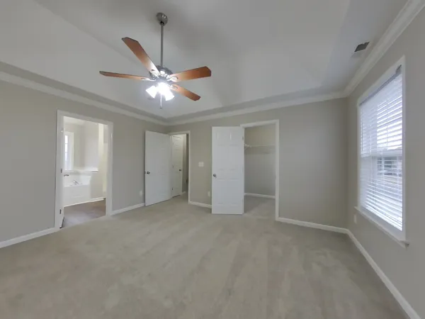 a view of an empty room with a ceiling fan and window