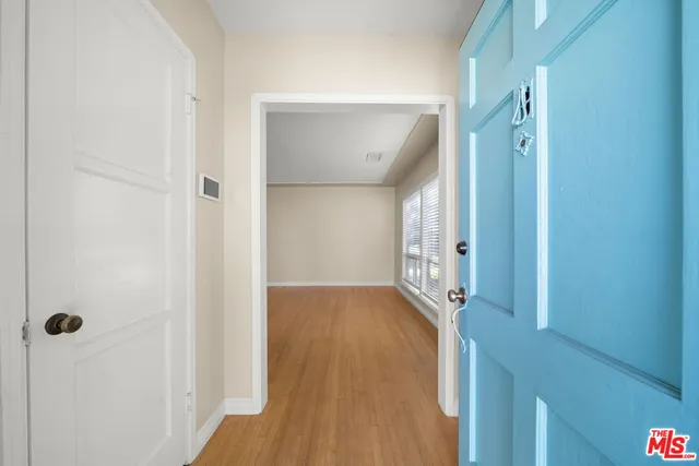 a view of a hallway with wooden floor and staircase