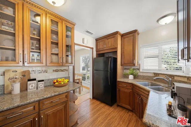 a kitchen with granite countertop a refrigerator and a sink