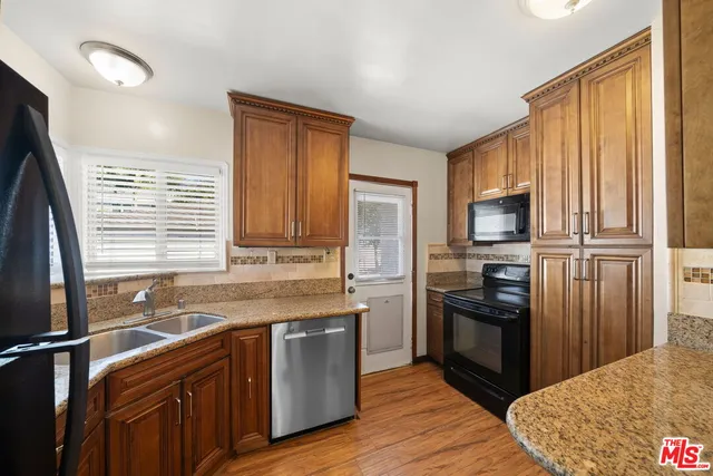 a kitchen with granite countertop a sink stove and refrigerator