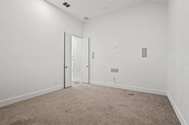 a large kitchen with kitchen island a stove a sink a refrigerator and white cabinets with wooden floor