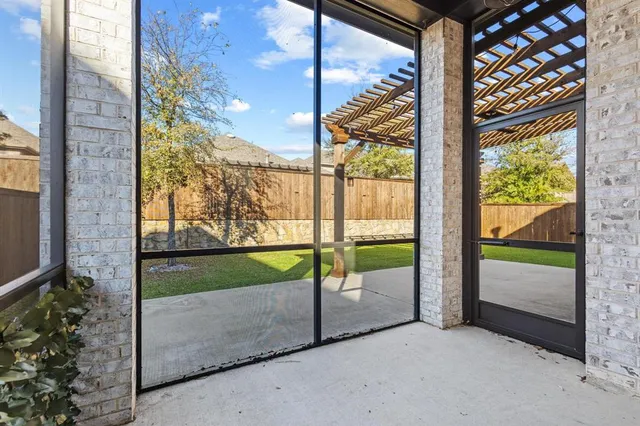 a view of a backyard with brick wall and a large tree
