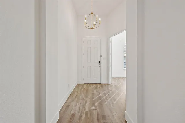 a view of a hallway with wooden floor and a window