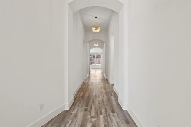 a view of a hallway with wooden floor