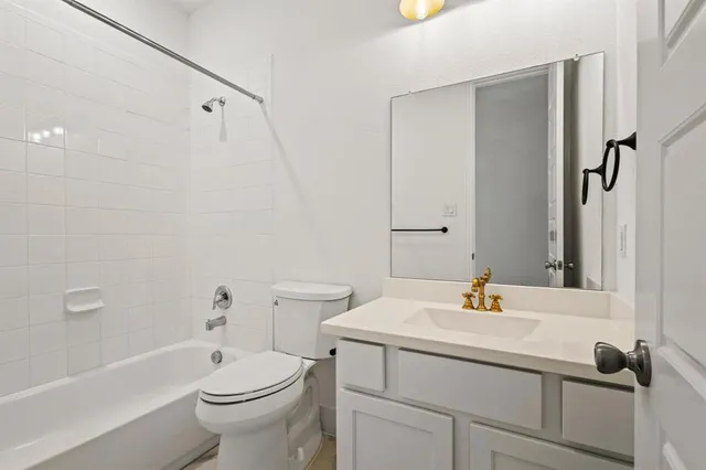 an empty room with windows and chandelier fan