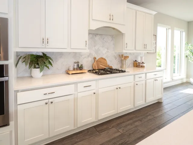 a kitchen with white cabinets and white appliances
