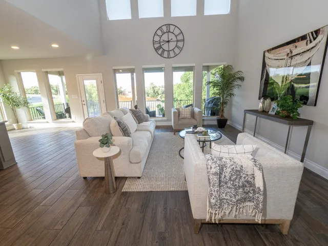 a living room with furniture a large window and wooden floor