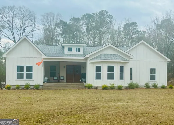 a front view of a house with a garden