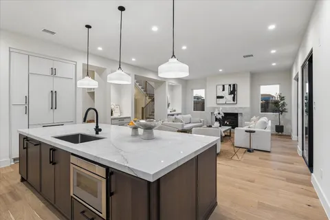 a kitchen with a dining table chairs sink and wooden floor