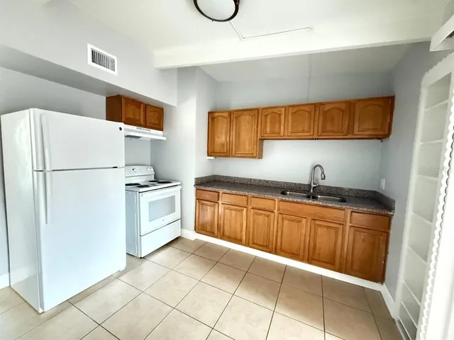 a kitchen with a refrigerator sink and cabinets