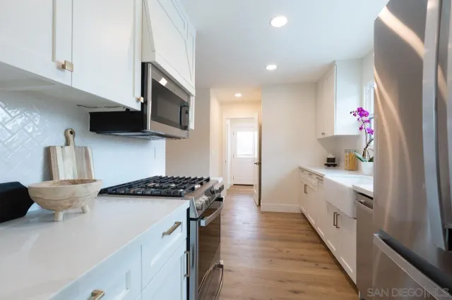 a kitchen with stainless steel appliances a sink stove and refrigerator