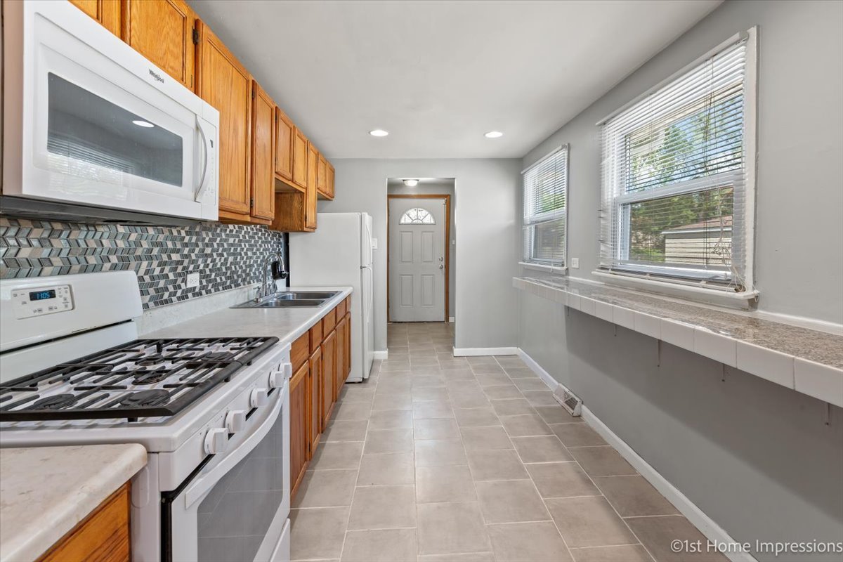 16640 Marshfield Avenue Markham, IL 60428 - Photo 3 of 20 a kitchen with stainless steel appliances granite countertop a stove and a sink