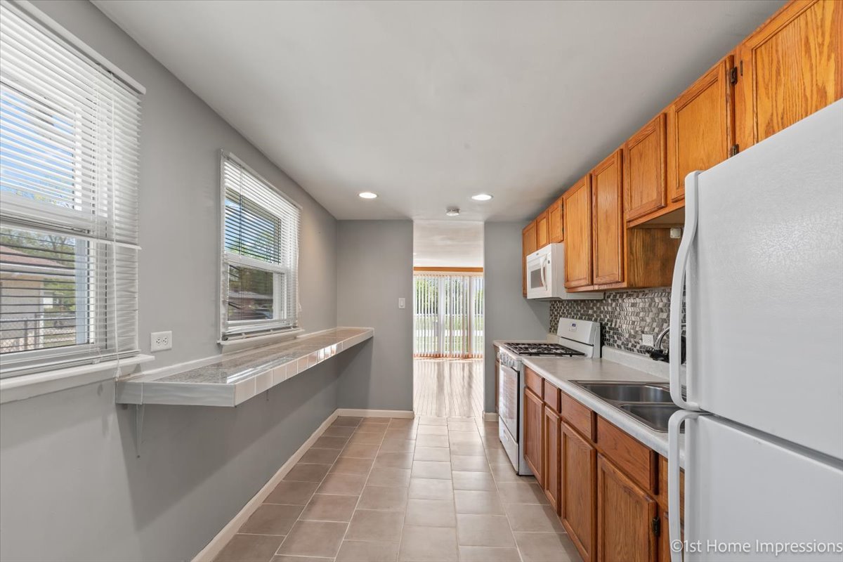 16640 Marshfield Avenue Markham, IL 60428 - Photo 4 of 20 a large white kitchen with a large window