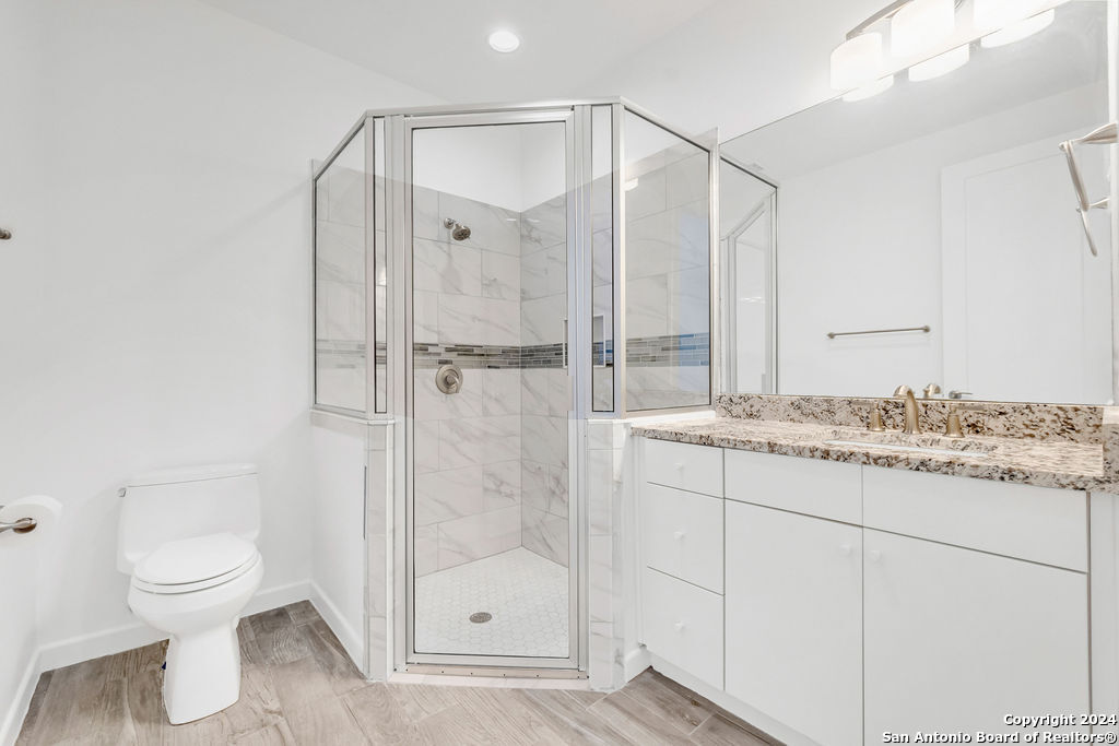 1303 Summerfield San Antonio, TX 78258 - Photo 22 of 27 a bathroom with a granite countertop sink a toilet and shower