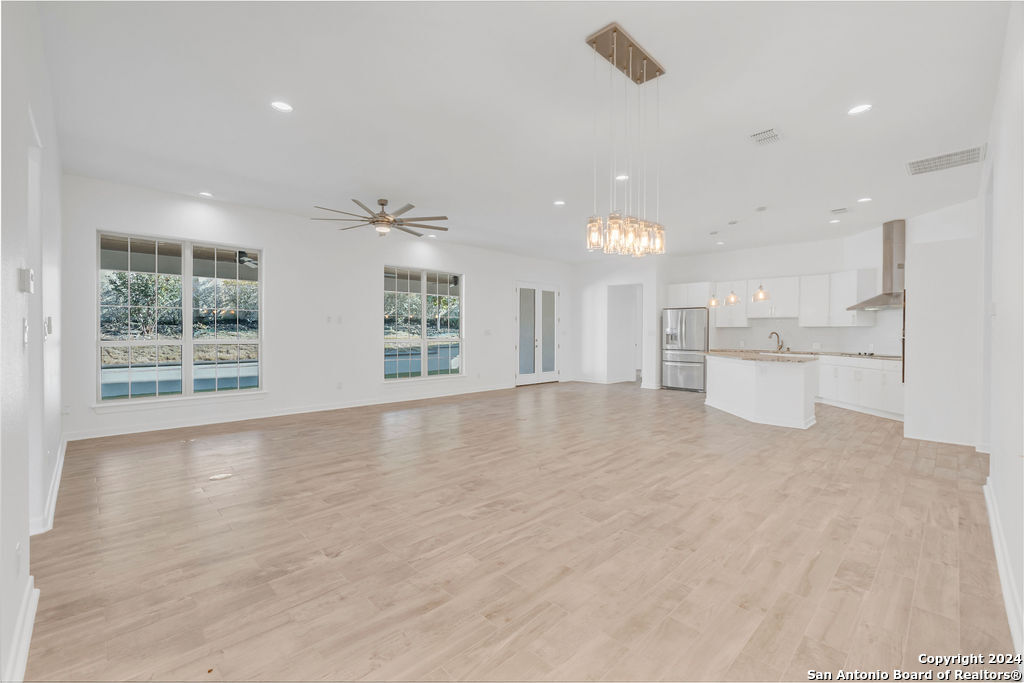 1303 Summerfield San Antonio, TX 78258 - Photo 4 of 27 a view of an empty room with a window and wooden floor