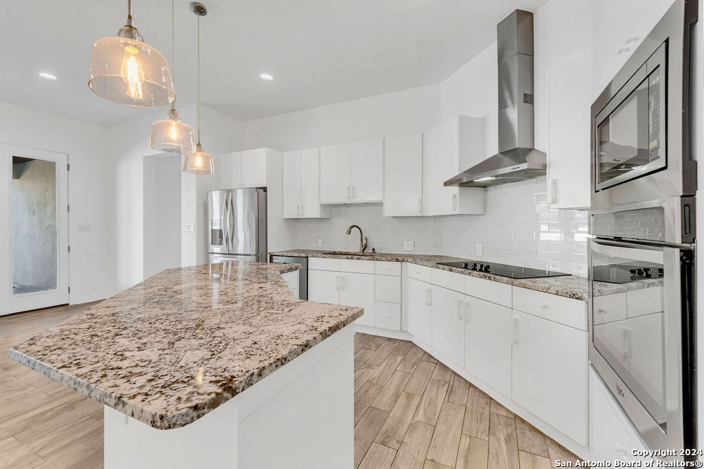 1303 Summerfield San Antonio, TX 78258 - Photo 6 of 27 a kitchen with stainless steel appliances granite countertop a sink stove and refrigerator